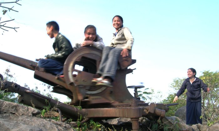 Kids riding on an old spinning Russian gun emplacement.
