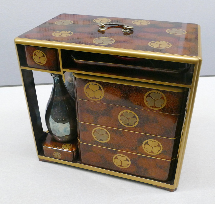 a beautifully lacquered box containing four bento boxes, two sake bottles, and a tray