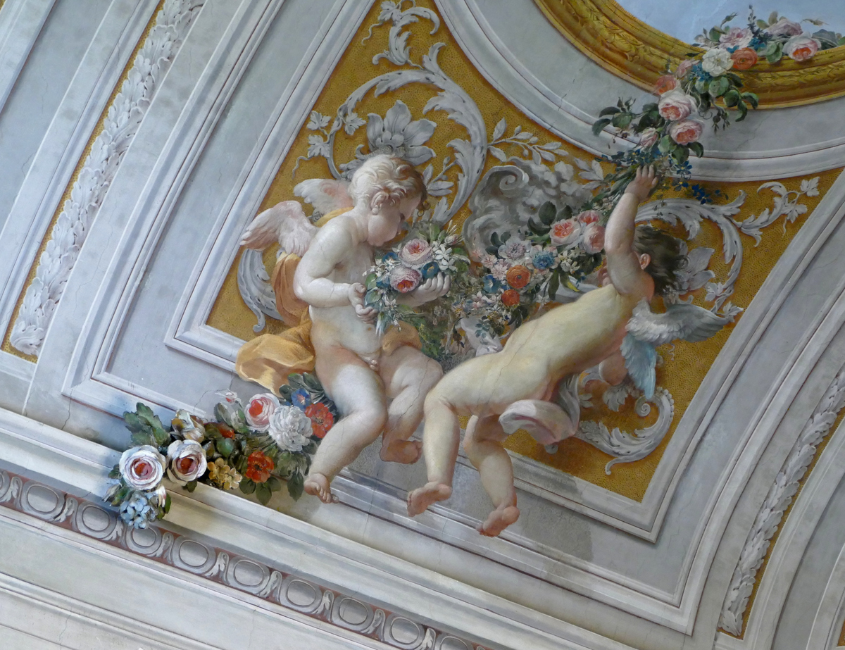 cherubs at play with a trail of roses, that eventually turn from painting to solid painted plaster
